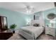 Cozy bedroom features an aqua wall paint, a ceiling fan, and two bedside tables at 9729 Heatherwood Ct, Orlando, FL 32825