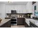 Well-equipped kitchen featuring stainless steel appliances, white cabinets and granite countertops at 9729 Heatherwood Ct, Orlando, FL 32825