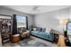 Cozy living room featuring stylish blue sofa, accent chair, ceiling fan, and decor at 9729 Heatherwood Ct, Orlando, FL 32825