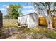 Backyard shed featuring a side door, windows, garden boxes, and white tubular supports at 9729 Heatherwood Ct, Orlando, FL 32825