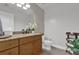 Bathroom featuring a granite countertop vanity, wooden cabinets, white toilet, and decorative plants at 101 S Eola Dr # 509, Orlando, FL 32801