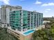 Modern condominium building featuring glass balconies and an outdoor pool at 101 S Eola Dr # 509, Orlando, FL 32801