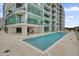Exterior shot of a community pool at an apartment building with clear blue water, tiled deck, and modern building design at 101 S Eola Dr # 509, Orlando, FL 32801