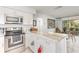 Bright kitchen with stainless steel appliances, white cabinetry, and a marble countertop island with adjacent dining space at 10339 Manila Bay Dr, Orlando, FL 32821