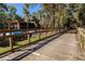 Wooden walkway leading to the complex, surrounded by lush landscaping and providing a peaceful path at 110 Cypress Woods Ct # 3D, Deltona, FL 32725