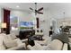 Bright living room with a ceiling fan, television, and dark wood fireplace entertainment center at 1112 Narcoossee Del Sol Blvd, St Cloud, FL 34771