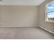 Bedroom featuring neutral carpeting, base trim, and a window for natural light at 1132 Clay Blvd, Tavares, FL 32778