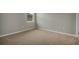 Cozy bedroom featuring neutral carpeting, base trim, and a window for natural light at 1132 Clay Blvd, Tavares, FL 32778