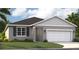 Charming single-story home featuring a two-car garage, well-maintained lawn, and traditional architectural details at 1132 Clay Blvd, Tavares, FL 32778