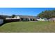A spacious backyard featuring lush green grass, a concrete patio, a shed, and fences for privacy at 12151 Goldenstar Ln, Clermont, FL 34711