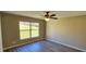 Comfortable bedroom features wood-look flooring, a large window, and a ceiling fan for a relaxing space at 12151 Goldenstar Ln, Clermont, FL 34711