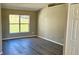 Bright bedroom with wood-look flooring, a large window, and neutral paint, creating a serene atmosphere at 12151 Goldenstar Ln, Clermont, FL 34711