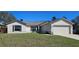 Charming single-story home with a well-maintained lawn and attached two-car garage on a sunny day at 12151 Goldenstar Ln, Clermont, FL 34711