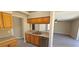 Kitchen featuring stainless steel sink, matching dishwasher and wood cabinets, and an open view to the dining area at 12151 Goldenstar Ln, Clermont, FL 34711