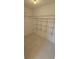 Spacious walk-in closet featuring wire shelving and neutral tile flooring at 12151 Goldenstar Ln, Clermont, FL 34711