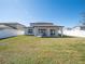A spacious backyard offers green grass, and a covered patio, creating a welcoming outdoor oasis at 1217 Michelangelo Ln, Winter Haven, FL 33884