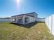 Backyard featuring green grass, white fencing, and a covered patio for relaxing or dining at 1217 Michelangelo Ln, Winter Haven, FL 33884