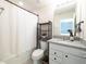 A bathroom with a shower/tub combination, dark shelving, and white vanity with granite countertops at 1217 Michelangelo Ln, Winter Haven, FL 33884
