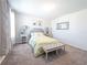 Bright bedroom featuring a gray upholstered bed frame, bench, and neutral decor at 1217 Michelangelo Ln, Winter Haven, FL 33884