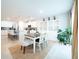 Bright dining area open to the kitchen with a large dining table and views of built in shelving at 1217 Michelangelo Ln, Winter Haven, FL 33884