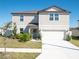 Charming two-story home with neutral siding, manicured lawn, and attached two-car garage at 1217 Michelangelo Ln, Winter Haven, FL 33884