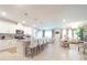 Open concept kitchen and living room with white cabinets, island seating, and modern decor at 1217 Michelangelo Ln, Winter Haven, FL 33884