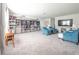 Fun living room with carpet, television, and large bookshelf filled with collectibles at 1217 Michelangelo Ln, Winter Haven, FL 33884