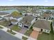 Aerial view of a residential community with a lake, neatly landscaped lawns, and multi-car driveways at 1240 Lone Palm Way, St Cloud, FL 34771
