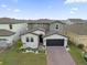 Beautiful two-story home with manicured lawn, paver driveway, and attached two-car garage at 1240 Lone Palm Way, St Cloud, FL 34771