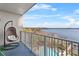 Balcony featuring hanging chair with expansive view of the pool and lake at 13415 Blue Heron Beach Dr # 610, Orlando, FL 32821