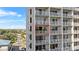 Exterior balcony view of a high-rise condo showcasing large windows, a balcony, and a view of palm trees at 13415 Blue Heron Beach Dr # 610, Orlando, FL 32821