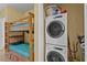 Functional laundry area featuring stackable washer/dryer unit adjacent to a cozy bunk bed setup at 13415 Blue Heron Beach Dr # 610, Orlando, FL 32821