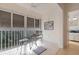 Cozy tiled balcony with seating, fan, storm shutters, and pleasant view to trees beyond the railing at 13801 Timberland Dr # 202, Orlando, FL 32824