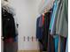 Walk-in closet features ample hanging space with rods on both sides and a luggage rack at 13801 Timberland Dr # 202, Orlando, FL 32824