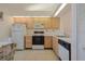 Clean kitchen featuring white appliances, light wood cabinetry, and neutral countertops at 13801 Timberland Dr # 202, Orlando, FL 32824