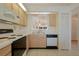 Open kitchen with white countertops, wood cabinets, black appliances, and pass-through to dining area at 13801 Timberland Dr # 202, Orlando, FL 32824