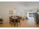 Open-plan living and dining room with chandelier, vaulted ceilings, light wood floors, and balcony access at 13801 Timberland Dr # 202, Orlando, FL 32824