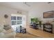 A well-lit living room with a ceiling fan, balcony access, and a wooden TV stand at 13801 Timberland Dr # 202, Orlando, FL 32824