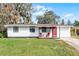 Charming single-story home with a bright red door and cozy front porch seating at 144 Delespine Dr, Debary, FL 32713