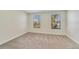 Bright bedroom featuring carpeted floors and two windows at 15088 Night Heron Dr, Winter Garden, FL 34787