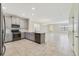 Spacious open kitchen with stainless appliances, gray cabinetry, tile floors, and view to living room at 15088 Night Heron Dr, Winter Garden, FL 34787