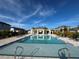 Community pool featuring a covered lounge area with seating and a clear blue sky above at 15364 Burgtheater Dr, Winter Garden, FL 34787