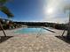 Community pool featuring a paved deck, lounge chairs, and palm trees on a sunny day at 15364 Burgtheater Dr, Winter Garden, FL 34787