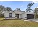 A modern single-story home with neutral tones, a well-kept lawn, and a driveway leading to the garage at 166 Marion Oaks Ln, Ocala, FL 34473