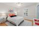 Inviting bedroom features natural light from shuttered window, complementing the hardwood floors and soft color palette at 1701 Clouser Ave, Orlando, FL 32804