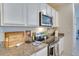 Kitchen detail highlighting granite countertops, stainless steel appliances, and white cabinets at 1750 Eagle Hammock Blvd, Eagle Lake, FL 33839