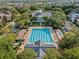 Aerial view of large community pool and surrounding area with lounge chairs and green space in a leafy neighborhood at 1859 Britlyn Aly, Orlando, FL 32814