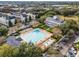 Birds eye view of community pool and clubhouse surrounded by lush greenery and parking with neighborhood in the background at 1859 Britlyn Aly, Orlando, FL 32814