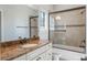 Bathroom featuring a shower-tub combo with glass door and white vanity with stone countertop at 1859 Britlyn Aly, Orlando, FL 32814