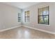 A cozy bedroom with natural light from the three windows and neutral walls at 1859 Britlyn Aly, Orlando, FL 32814